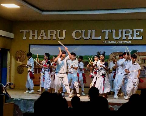       Cultural dance performance on a stage with 'Tharu Culture' signage.
  