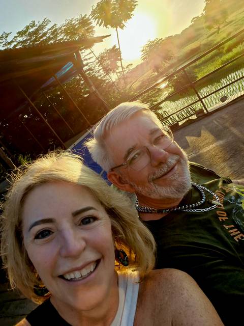 Selfie of a couple with a city street in the background.
