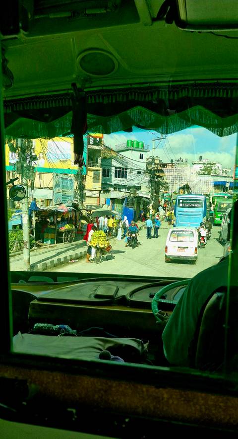       Busy street with people, buses, and street vendors.
  