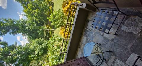       Balcony view over a lush garden.
  