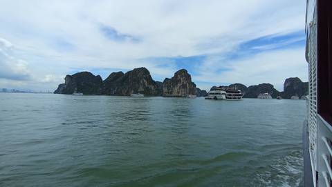 Boats and limestone formations in Halong Bay.