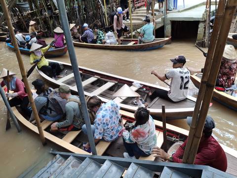 People paddling boats in a river during a tour.