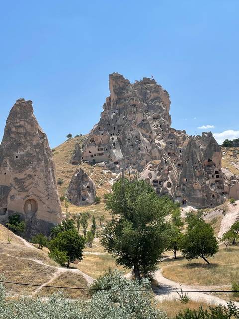 Rock formations and cave dwellings in a mountainous landscape.