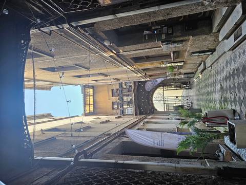 A narrow passage between old buildings with a semi-open roof.