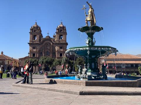       Fountain with a church in the background on a sunny day.
  