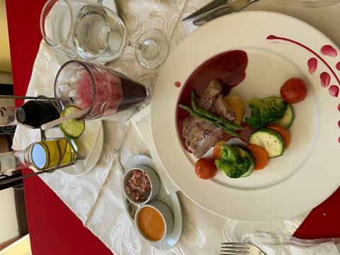       Gourmet meal with steak, vegetables, and a glass of juice.
  