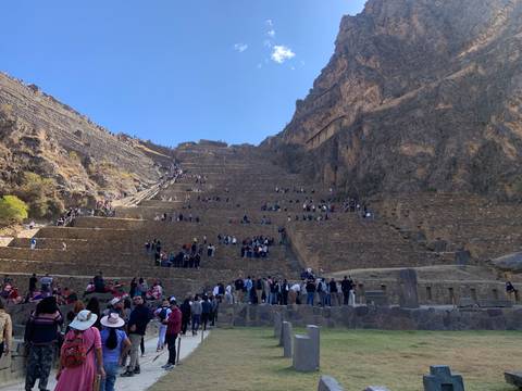       Inca ruins with terracing and many tourists visiting.
  