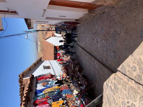       Street with market stalls and people walking.
  