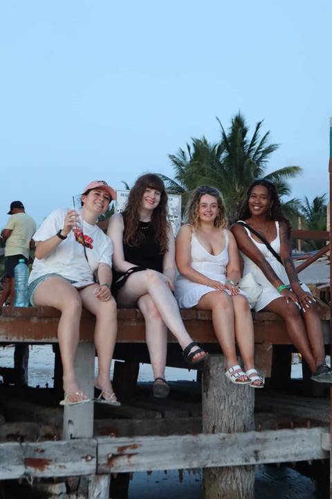       Group of people sitting with drinks on a platform.
  