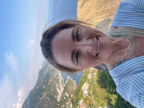       Person taking a selfie with coastal view.
  