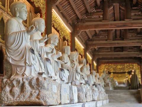 Row of statues inside a temple with intricate detailing.