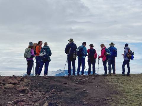 Hikers with trekking poles at a scenic viewpoint.