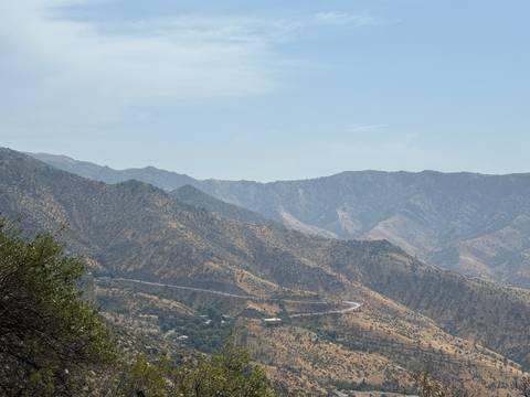 Mountain range with clear skies and long winding road.