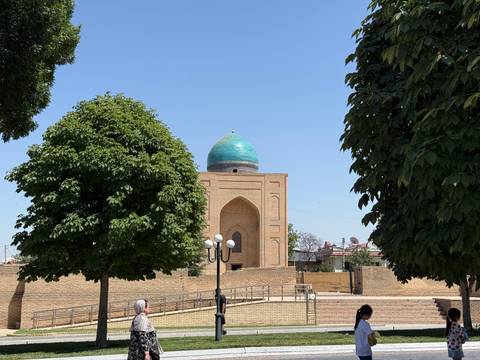 Historic building with a blue dome surrounded by trees.