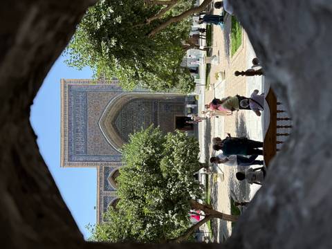 Intricate tile work on a mosque seen through an archway.