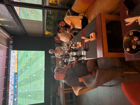 People dining in a restaurant watching sports.