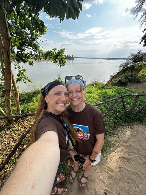       Selfie of two women near a river with greenery around.
  