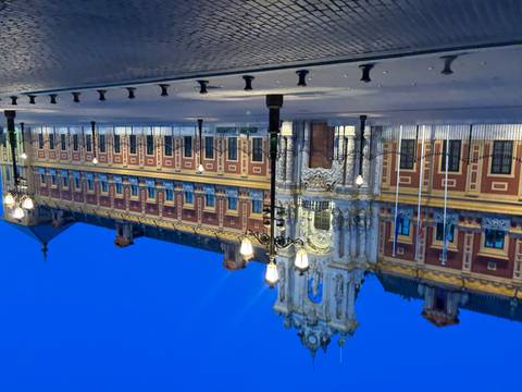       A historic building with ornate architectural details illuminated at night.
  