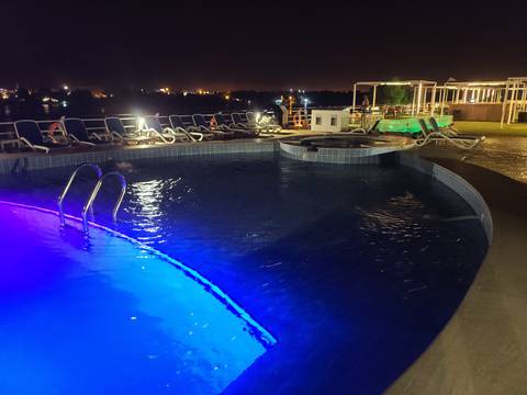 Pool deck at night with blue lights.