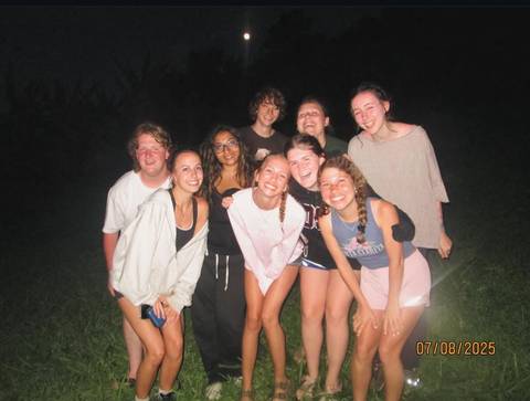      Group of people smiling at night time.
  