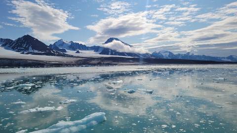 Picturesque view of icy waters with mountain range.