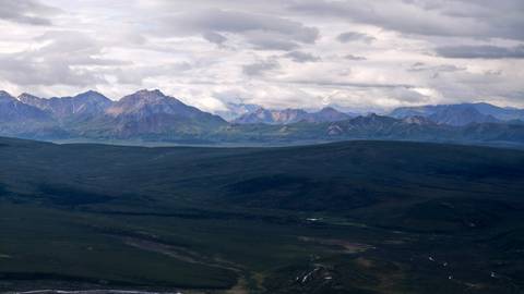       Expansive mountainous landscape under a cloudy sky.
  