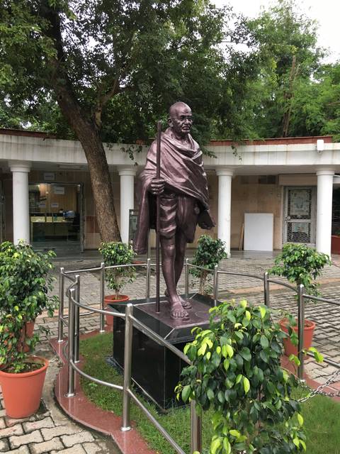 Statue of Mahatma Gandhi on a sidewalk.