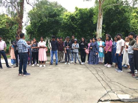 Group of people standing and listening in a park.