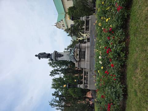 Statue in a park with flowers and trees