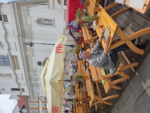       Outdoor seating area with an older man playing chess
  