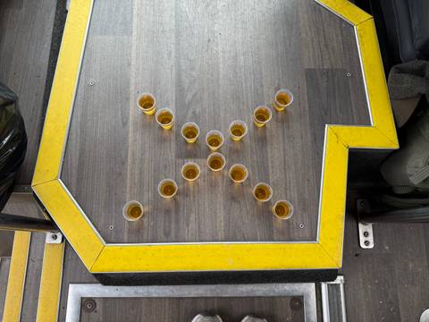       A pattern of small glasses arranged in a cross shape on a table.
  