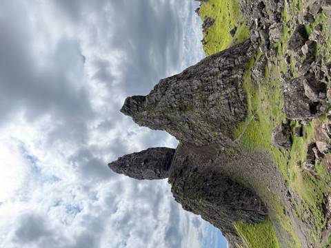       Rock formations with a path in a verdant landscape.
  