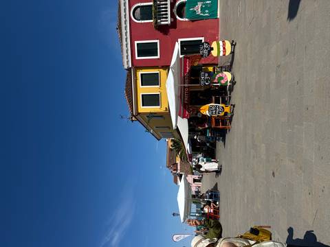 Colorful buildings and outdoor dining area on a sunny street.