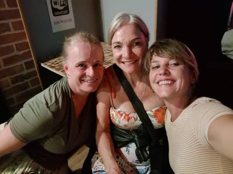       Three women posing indoors with happy expressions
  