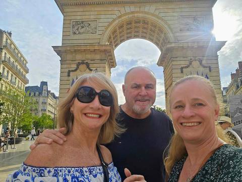       Group of people posing in front of city arch
  