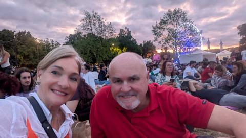       Couple enjoying a sunset festival with a ferris wheel in the background
  
