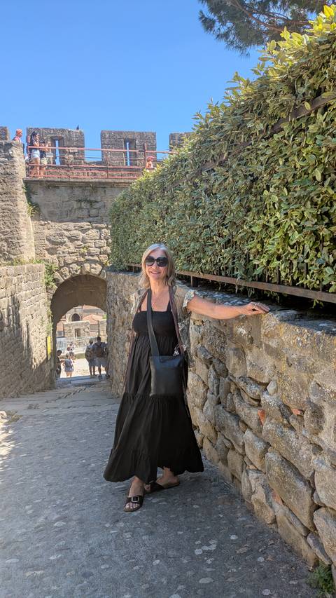       Woman standing on a stone path next to an archway
  