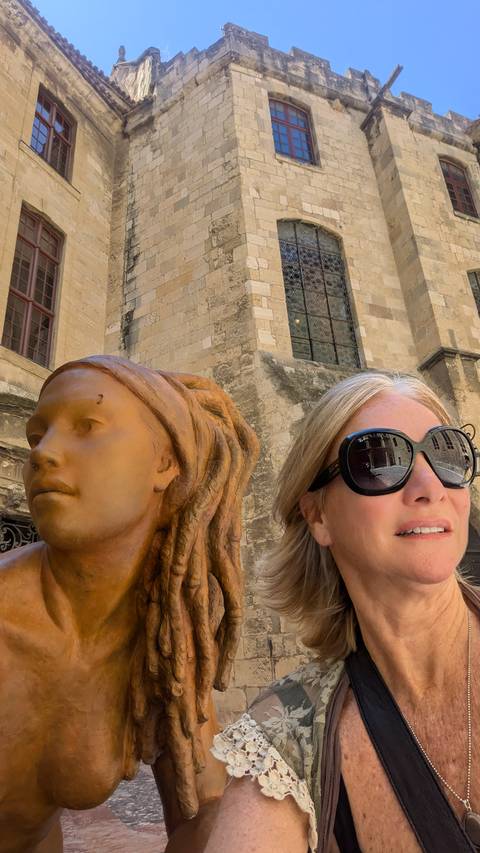       Woman with a statue in front of a historic building
  