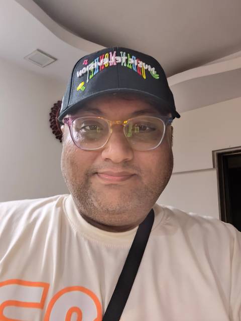 Close-up portrait of a person wearing glasses and a cap.