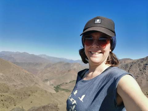 Woman taking a selfie with mountainous landscape.
