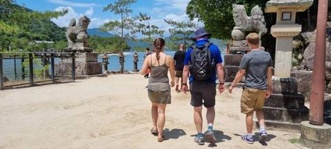 People walking on a sunny day with a scenic view.
