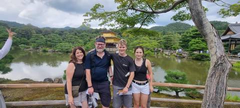       Family posing in front of a Buddhist temple landscape.
  