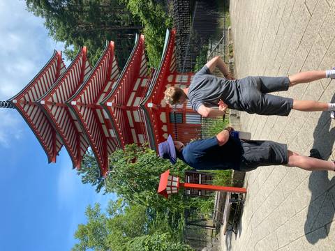 Two people viewing a traditional Japanese pagoda.
