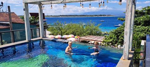 Two people in a pool with an ocean view.