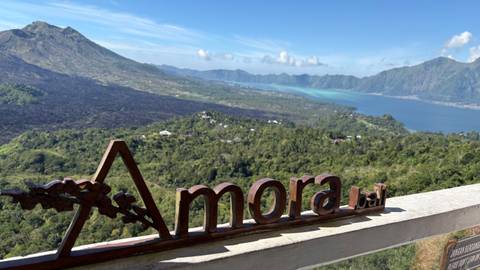 Panoramic view of mountain and lake with signage.