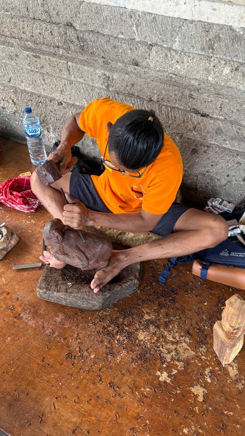      Person carving a wooden sculpture.
  