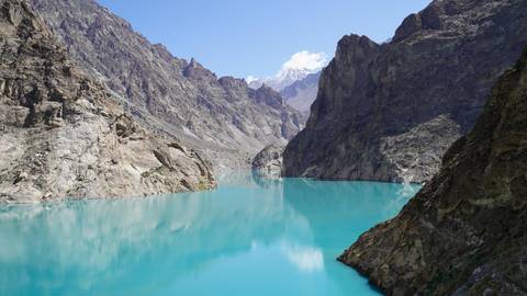 Turquoise lake surrounded by rugged mountains.