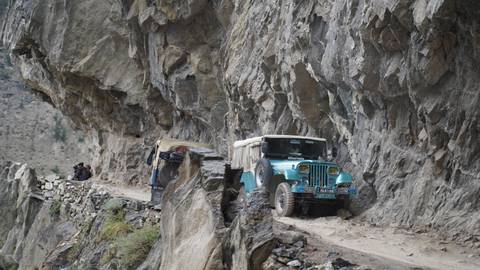 Vehicles on a narrow mountain road.