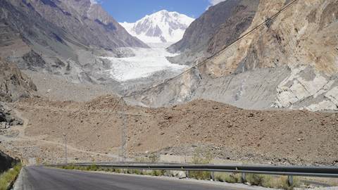 Mountain road leading to a snow-capped peak with a glacier.