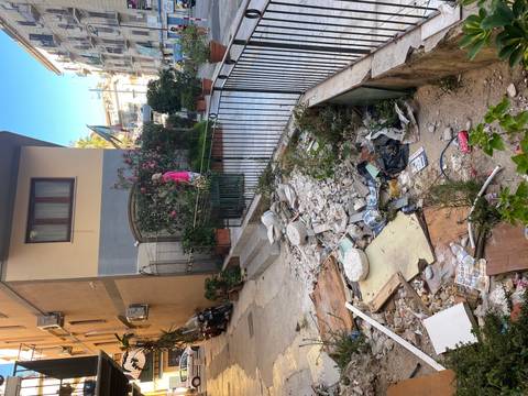 Rubble and debris in front of a building on a street.